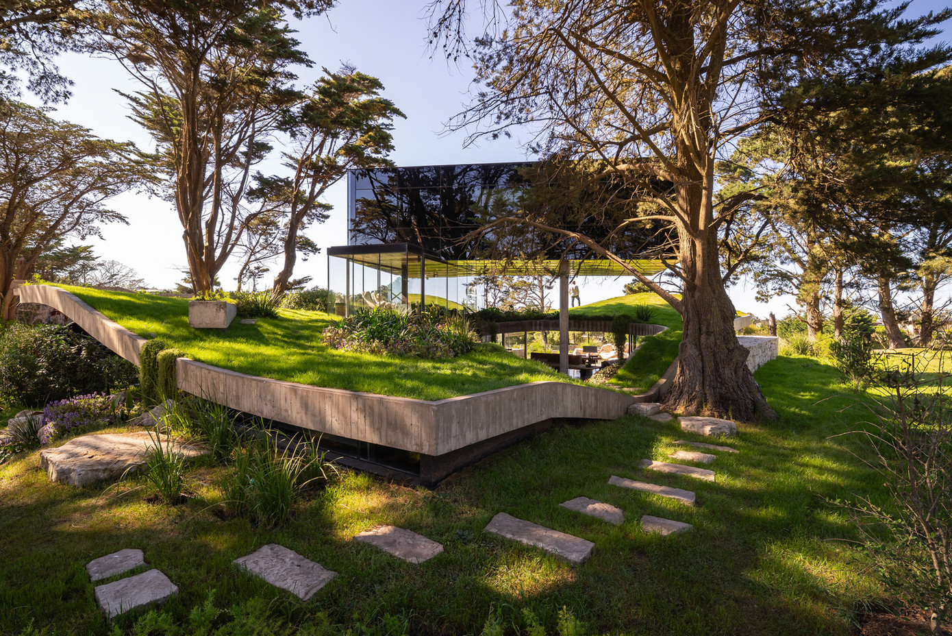 Đầu tiên, các kiến trúc sư trải lên địa hình một lớp bê tông uốn lượn như một tấm mền, ôm lấy mặt đất, sau đó phủ lên một lớp cỏ xanh mát.