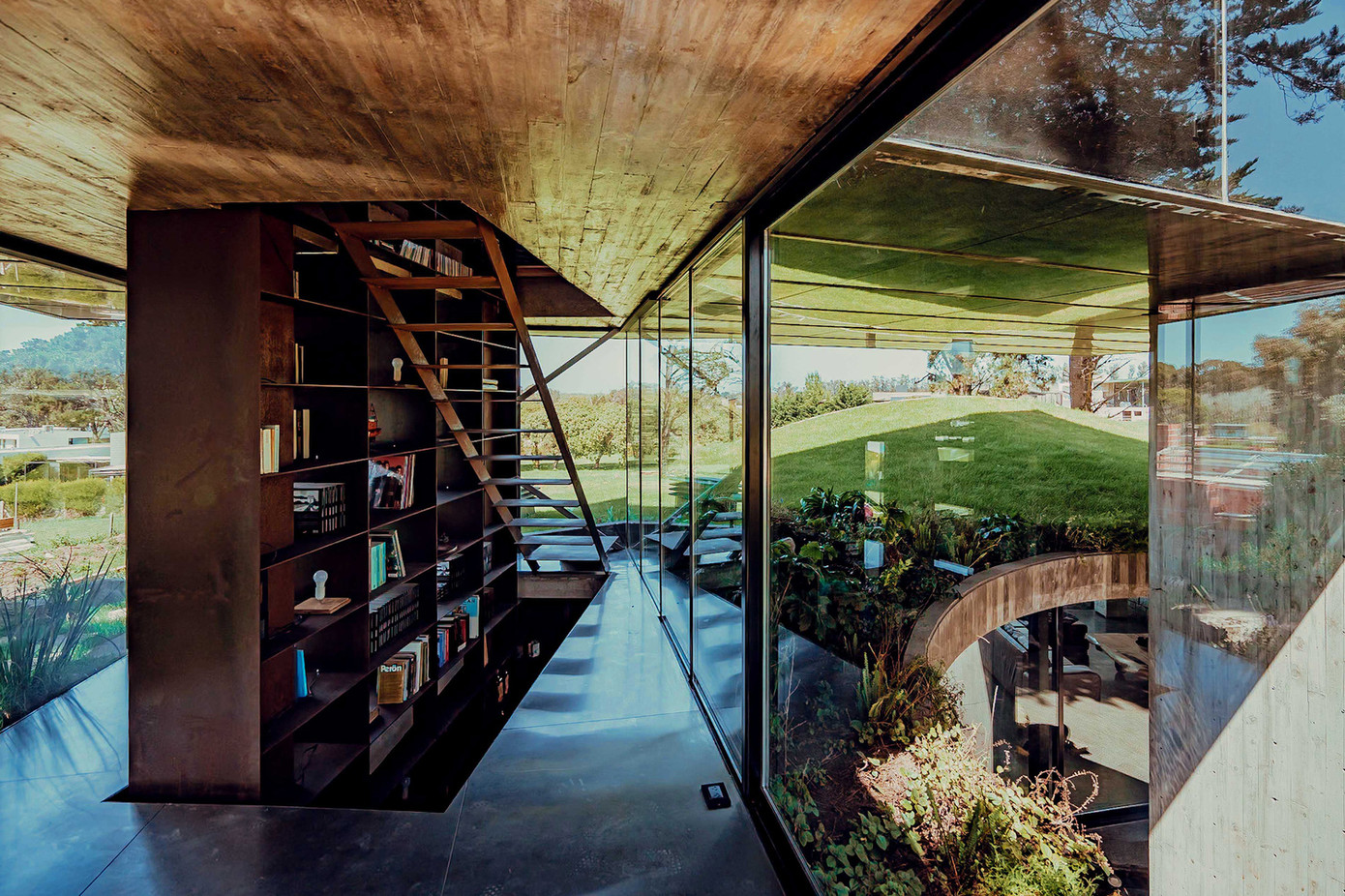 Tủ sách được đặt ngay cầu thang lên xuống, đóng vai trò như một vách ngăn.