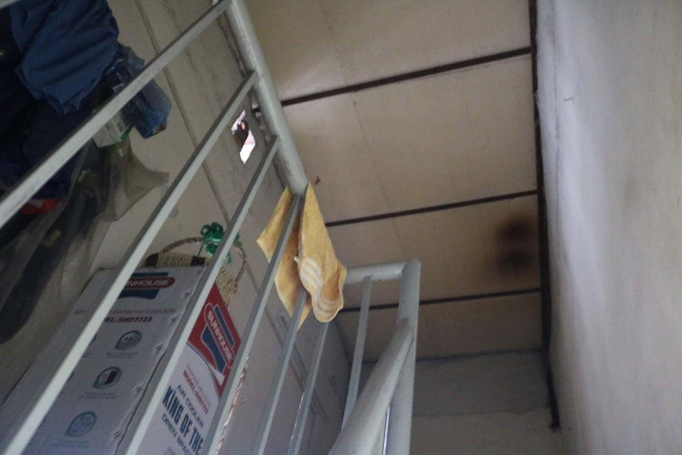 Cầu thang lên gác chỉ vừa cho một người đi, trên gác được bà N.T.B để những vật dụng ít dùng. Bà N.T.B than thở: "Tôi sống ở đây một mình, mùa hè như thế này rất nóng bức, khó chịu, hôm nào trời mưa thì nước ngập vào nhà bẩn thỉu, ẩm mốc nhưng chúng tôi không được phép xây dựng lại kiên cố vì đây đang là đất dự án. Không có sổ đỏ, có muốn chuyển nhượng hay xây sửa lại cũng khó, ai cố tình xây lên đều bị đập bỏ. Bây giờ nhiều nhà chỉ còn biết cơi nới bằng cách lắp các tấm tôn lên để tạo phòng, tăng diện tích sinh hoạt".