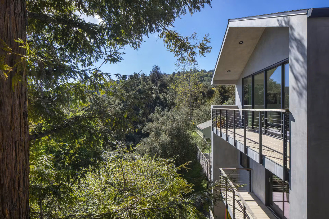 Phần mặt tiền của ngôi nhà được thiết kế độc đáo với sự kết hợp hài hoà giữa các vật liệu tự nhiên và những đường nét thanh thoát, cùng những khung cửa kính lớn nối từ trần đến sàn tạo một cái nhìn rộng mở với môi trường bên ngoài.