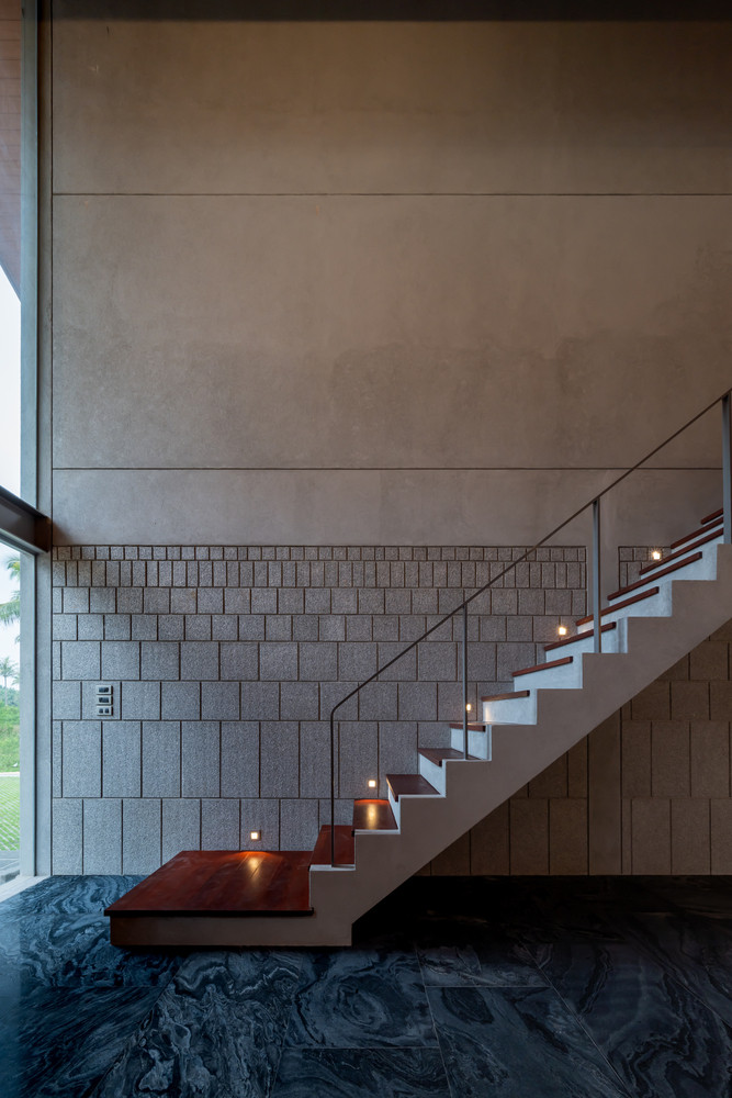 Cầu thang dẫn lên tầng hai chạy dọc theo bức tường tạo sự gọn gàng, ngăn nắp cho không gian.