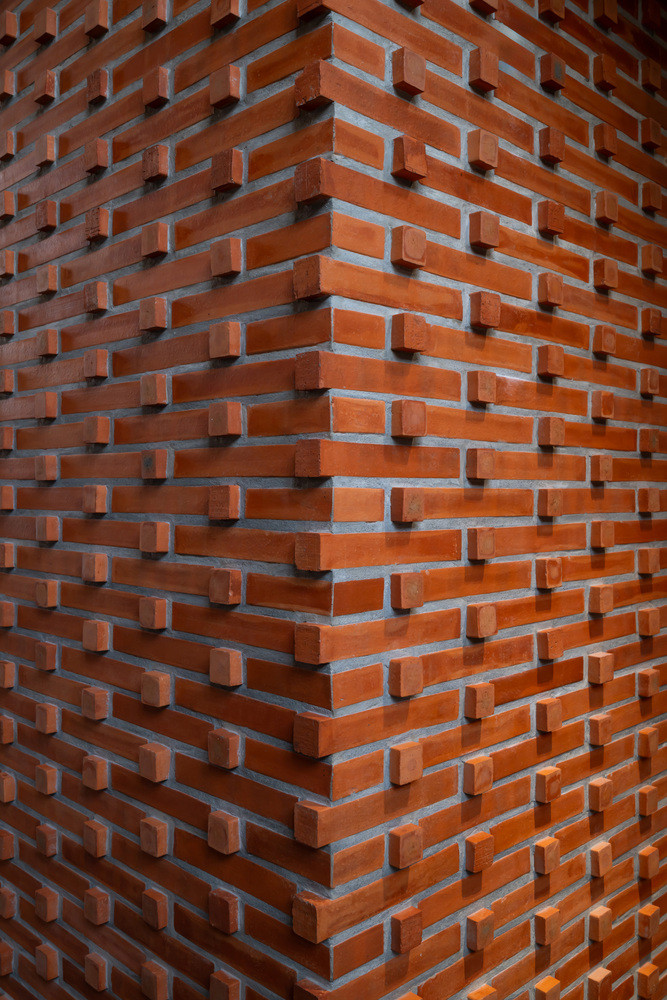 Tường gạch đỏ được sắp xếp đan vào nhau tạo nên một khối đặc biệt.