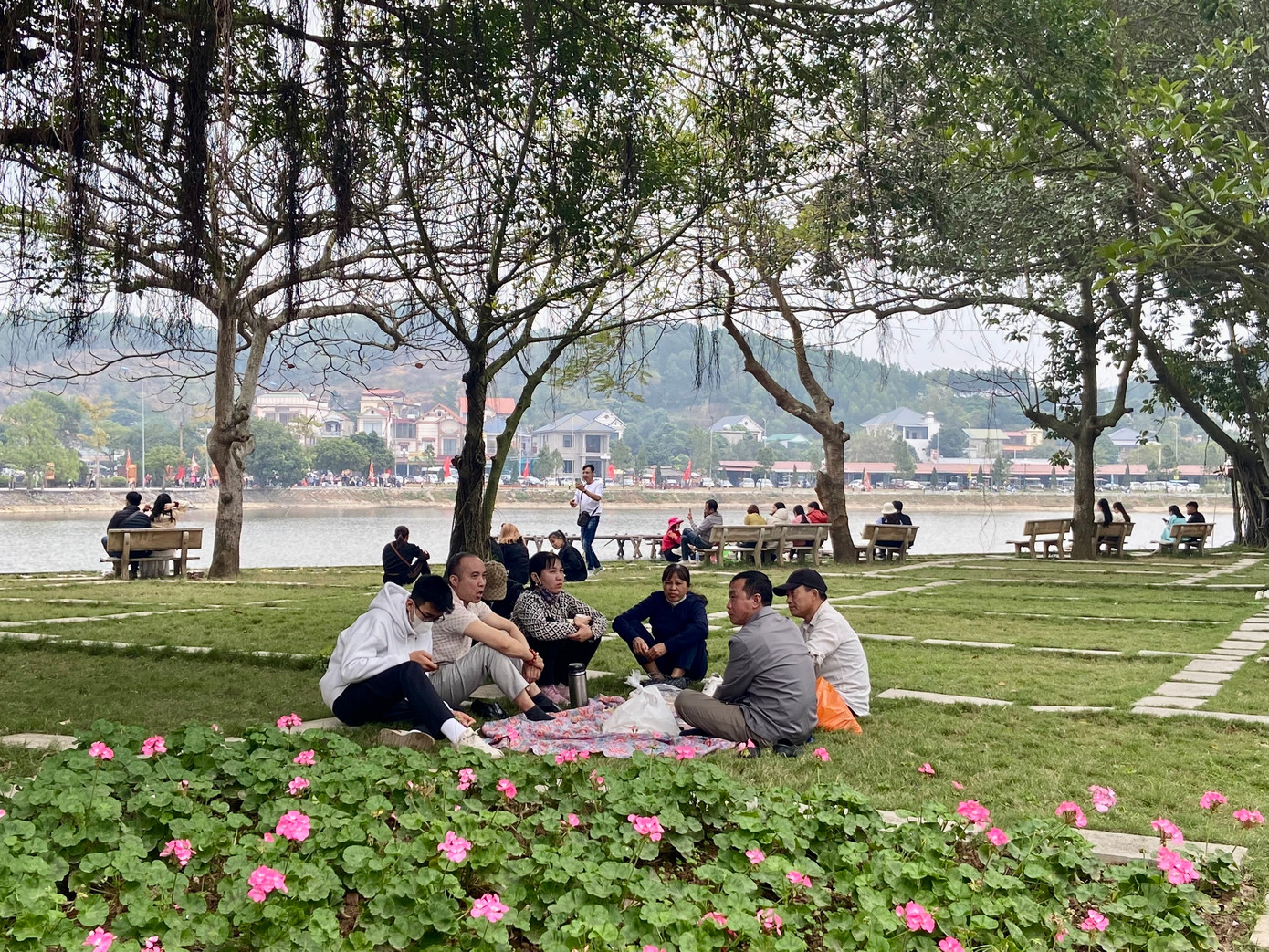 Sau khi tham quan khu di tích, người dân ngồi nghỉ tại bãi cỏ cạnh hồ.