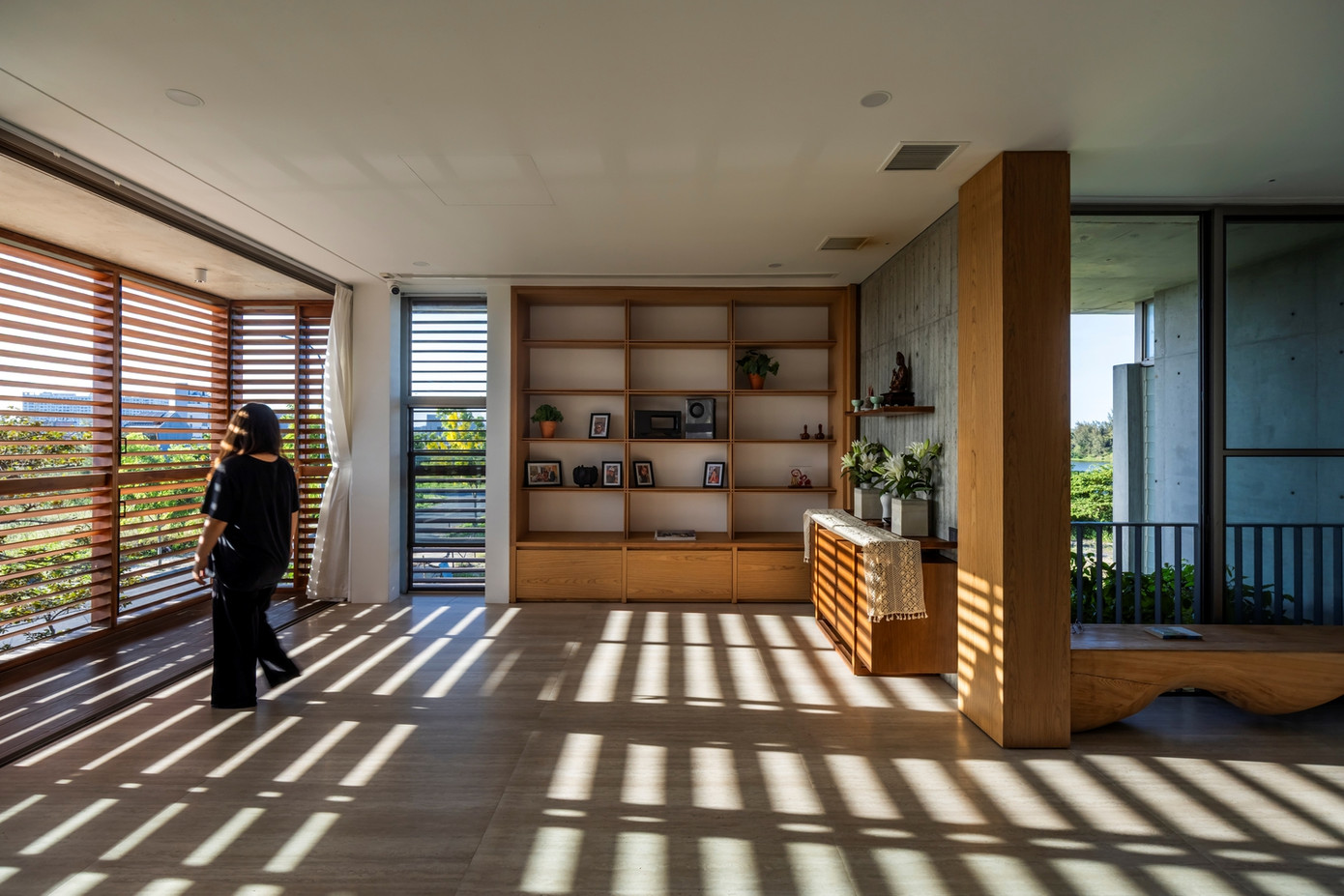 Hướng Tây của ngôi nhà là nơi đón nắng gắt nhất được "bảo vệ" bởi lớp vỏ kép gồm lớp chắn gỗ có điều chỉnh và lớp cây xanh, vừa giảm nhiệt, vừa tạo lá phổi xanh lọc không khí trước khi vào nhà.