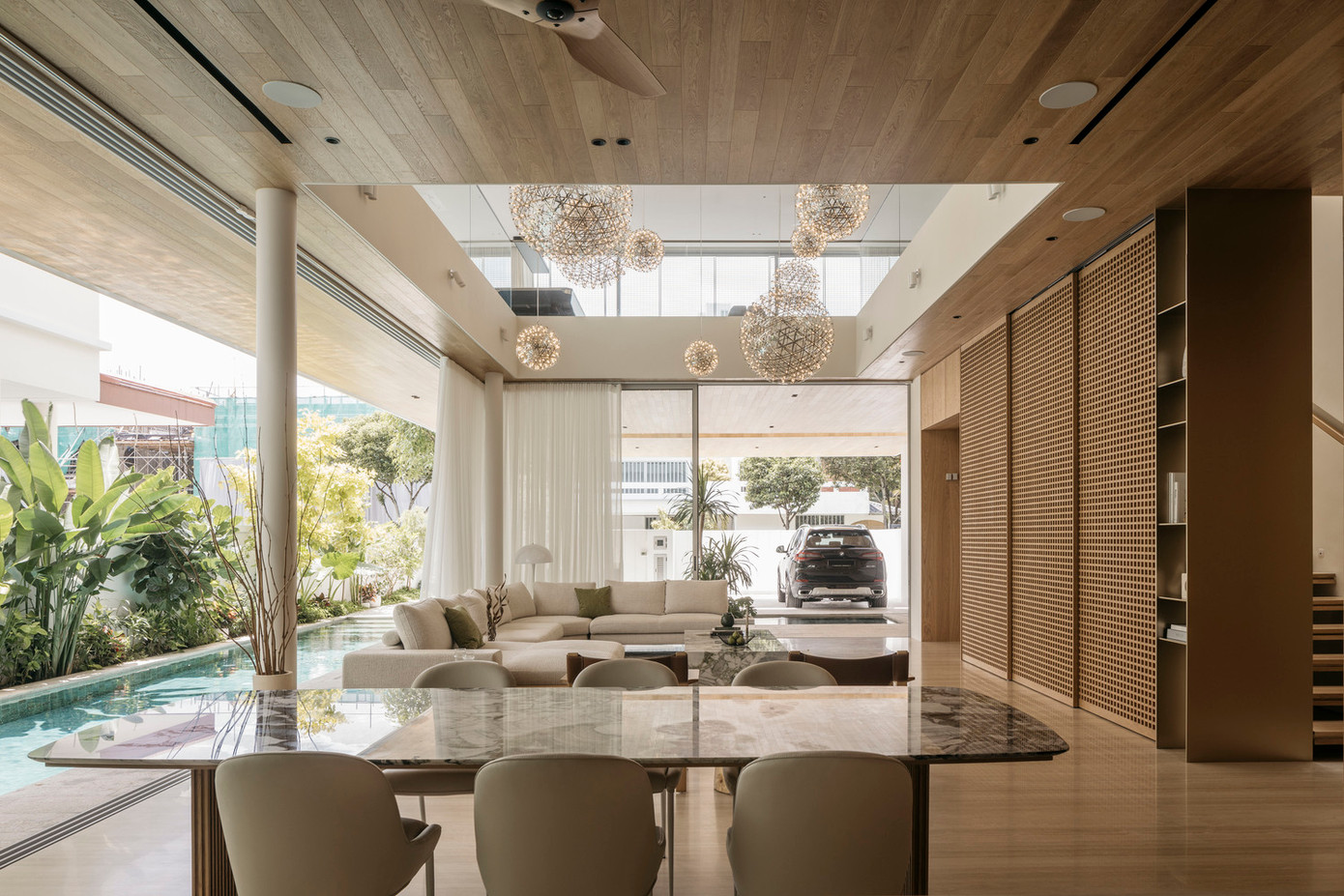 Trải nghiệm từ không gian bắt đầu từ lối đi qua khu vực sân nướng có mái che, trước khi bước vào phòng khách với chiều cao gấp đôi thông thường.