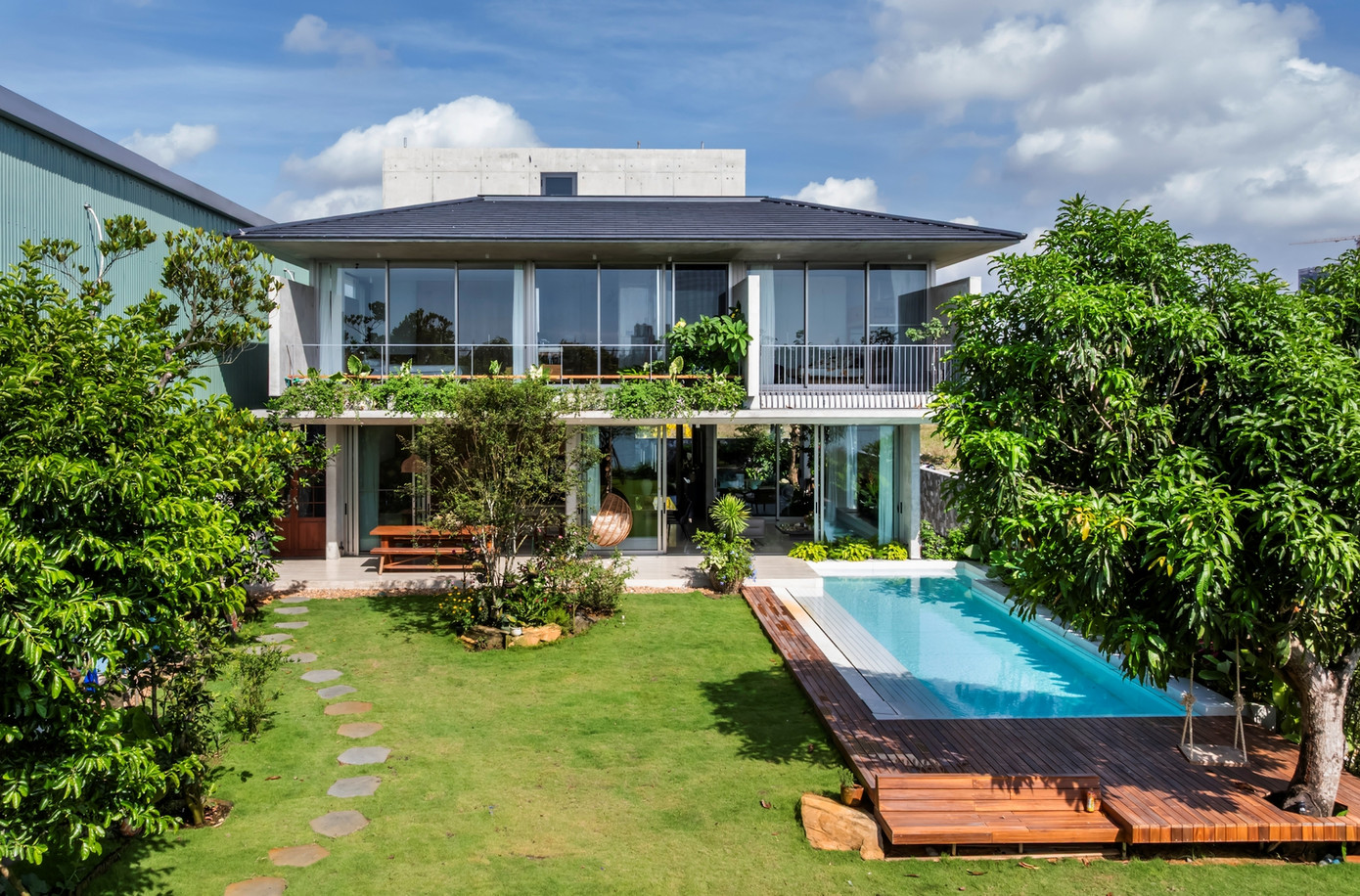 Ngôi nhà mở ra ở hướng Đông để đón gió sông mát lành, tận dụng khéo léo những tấm bê tông trần để vừa lọc ánh sáng ban mai vừa tạo độ thoáng cho không gian.