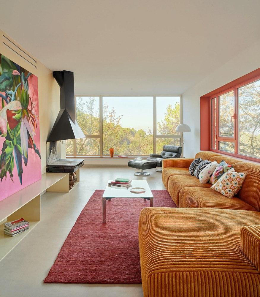 Từ đó, không gian mở rộng tới khu bếp, ban công, phòng ăn như tràn ra núi rừng, chỉ ngăn cách bằng bốn khung cửa trượt kính lớn.