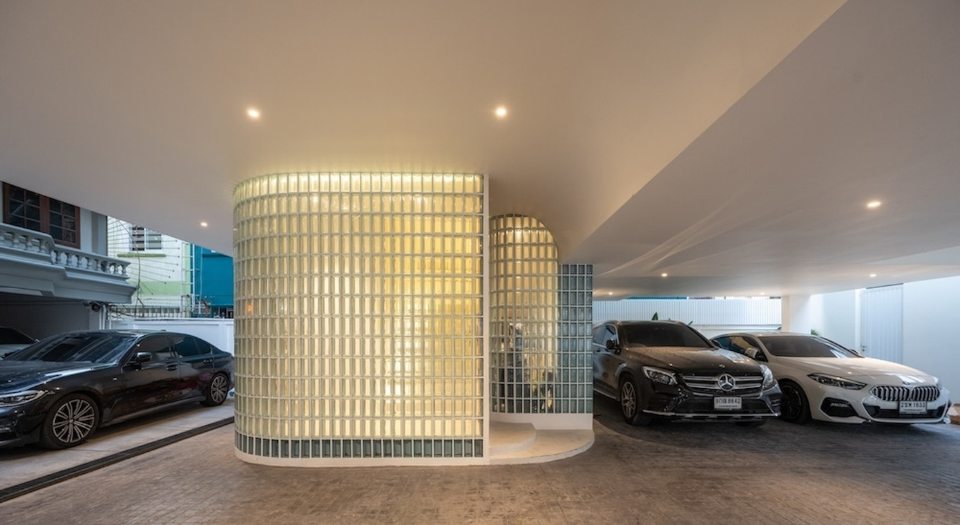 Ngôi nhà nằm đối diện với ngôi nhà cũ của bố mẹ gia chủ. Tầng một được thiết kế như một không gian mở với nhà để xe và một lối đi kết nối với ngôi nhà cũ.