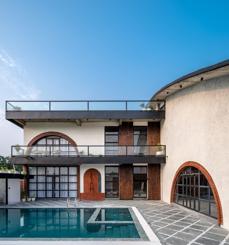 Phản chiếu trên mặt nước tĩnh lặng của hồ bơi, các vòm cong tạo thành những vòng tròn gần như hoàn hảo, biểu tượng cho sự liên tục và bất tận.