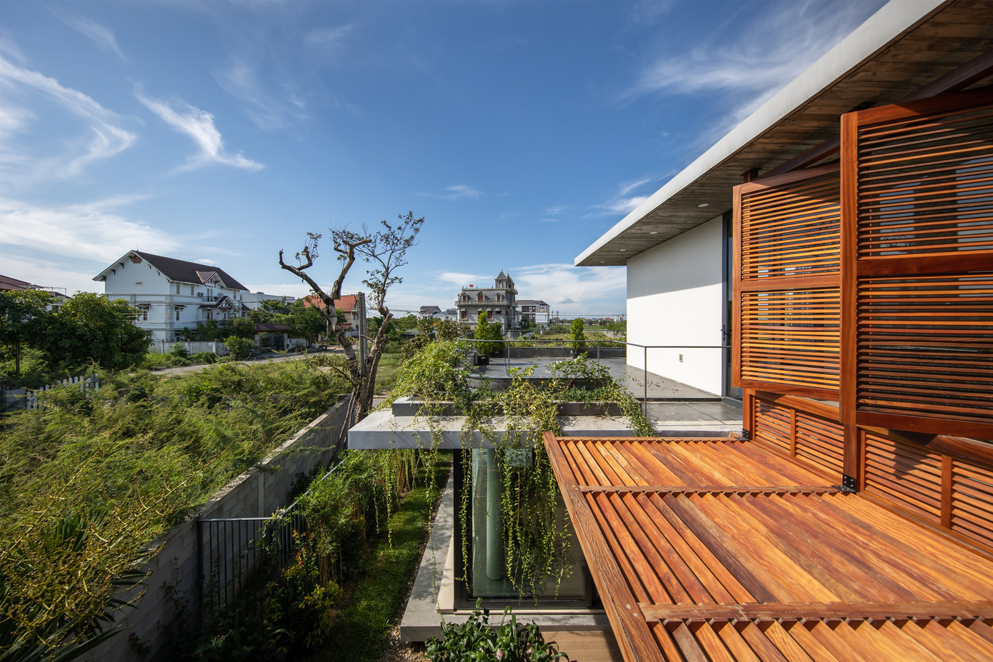 Hệ thống cây xanh trong nhà kết hợp với mái bê tông vươn rộng và hệ thống gỗ giúp bảo vệ ngôi nhà khỏi những tác động bất lợi của thiên nhiên.