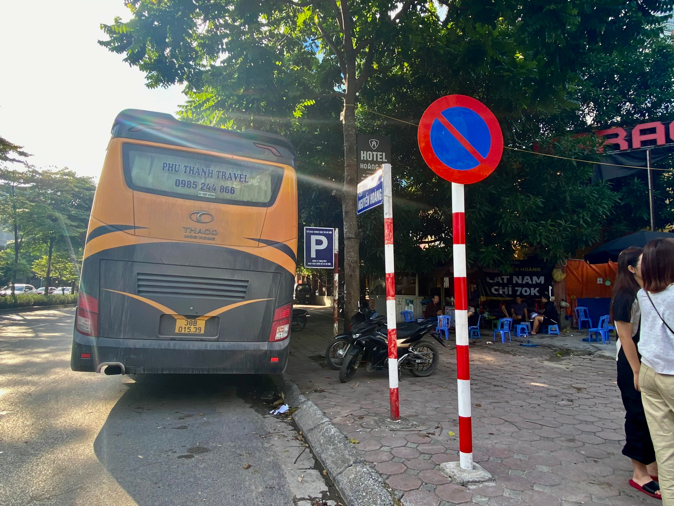 Biển báo "cấm đỗ xe" và "nơi đỗ xe" cắm gần nhau trên đường Nguyễn Hoàng.