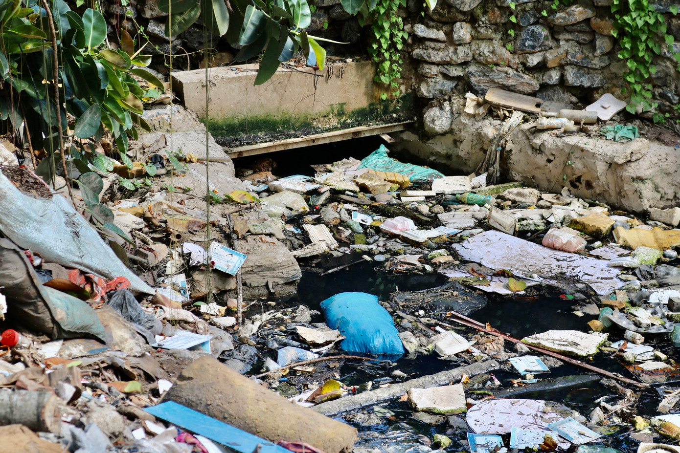 Ở đoạn cống, rác ùn ứ, gây tắc dòng chảy. "Những hôm trời mưa to, nước dâng cao, người dân chúng tôi sống ở đây rất là khổ sở, mùi hôi tanh nồng nặc không thể chịu được phải đóng của cả ngày", bà Thành sống gần bờ sông cho hay.