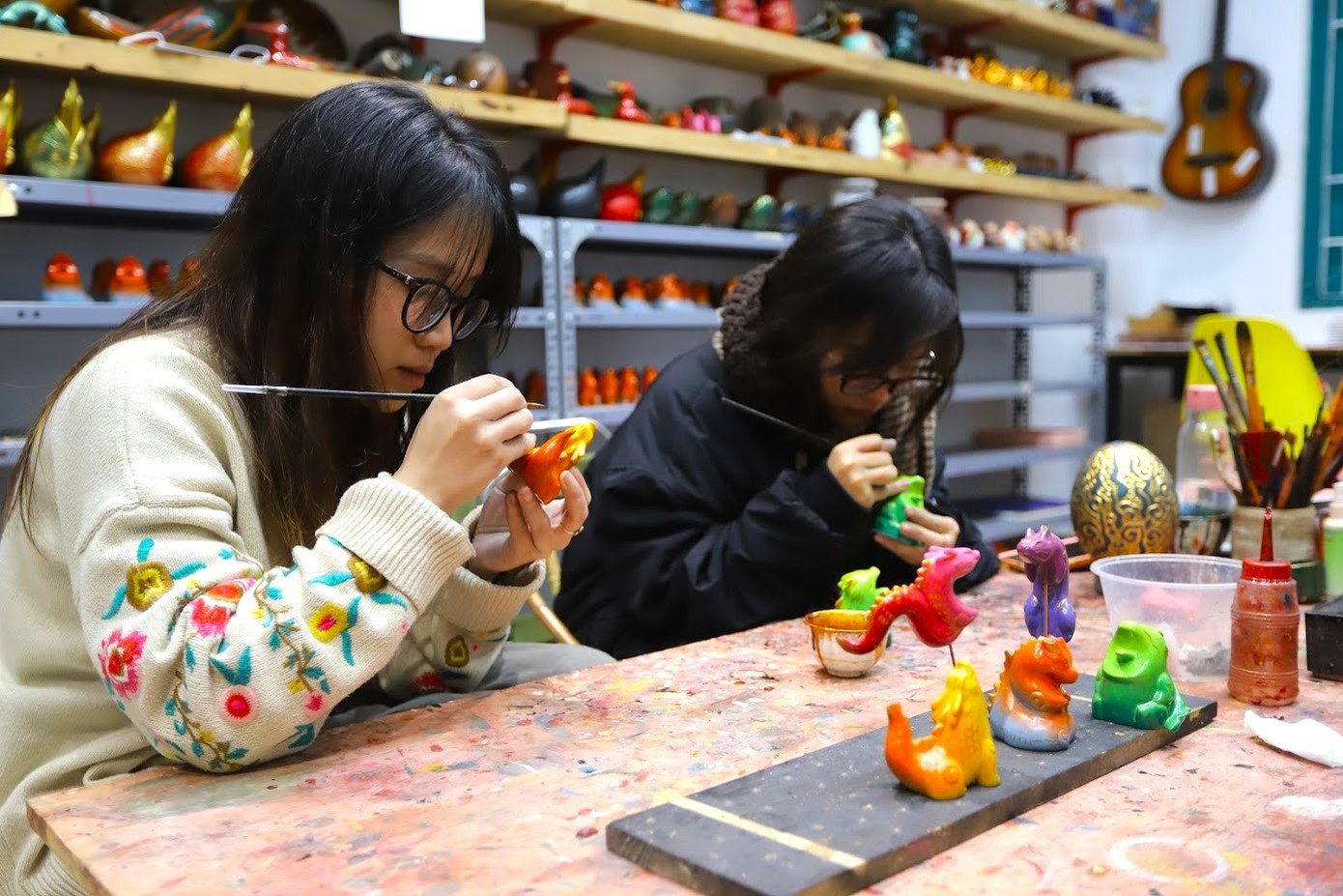 Những con rồng đều được làm hoàn toàn thủ công bằng bột đá ép kết hợp giữa bảng màu hiện đại của sơn phun và những nét vẽ tay sử dụng chất liệu sơn mài truyền thống. Những con rồng đều được làm hoàn toàn thủ công bằng bột đá ép kết hợp giữa bảng màu hiện đại của sơn phun và những nét vẽ tay sử dụng chất liệu sơn mài truyền thống.