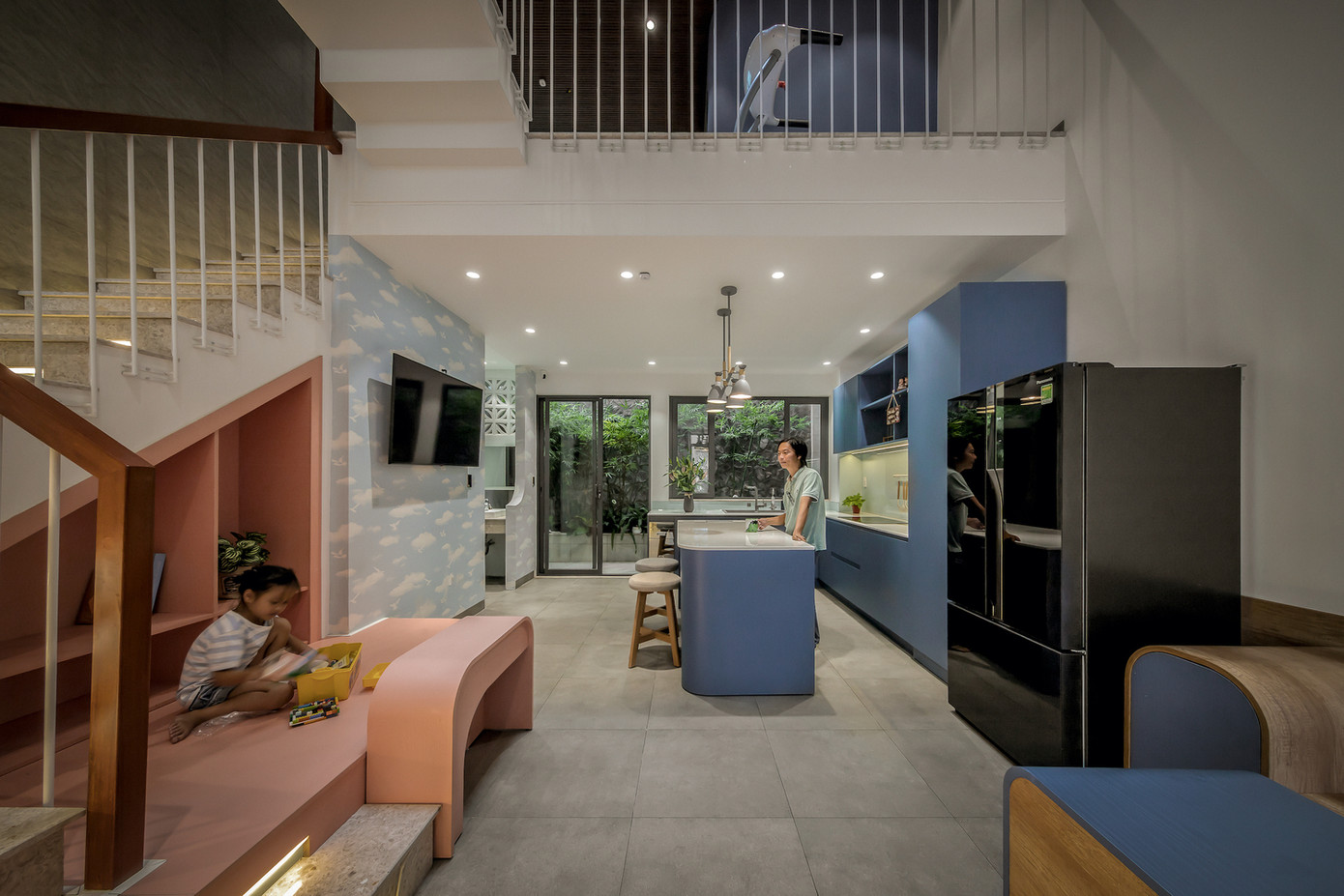 Tầng trệt là khu bếp và phòng ăn, nơi có thể nhìn thấy bầu trời qua giếng trời, mang lại cảm giác rộng mở và thư thái. Khu bếp được thiết kế liền kề sân sau, dù diện tích nhỏ nhưng vẫn đảm bảo sự tiện nghi, giúp người mẹ cảm thấy thoải mái khi nấu nướng.