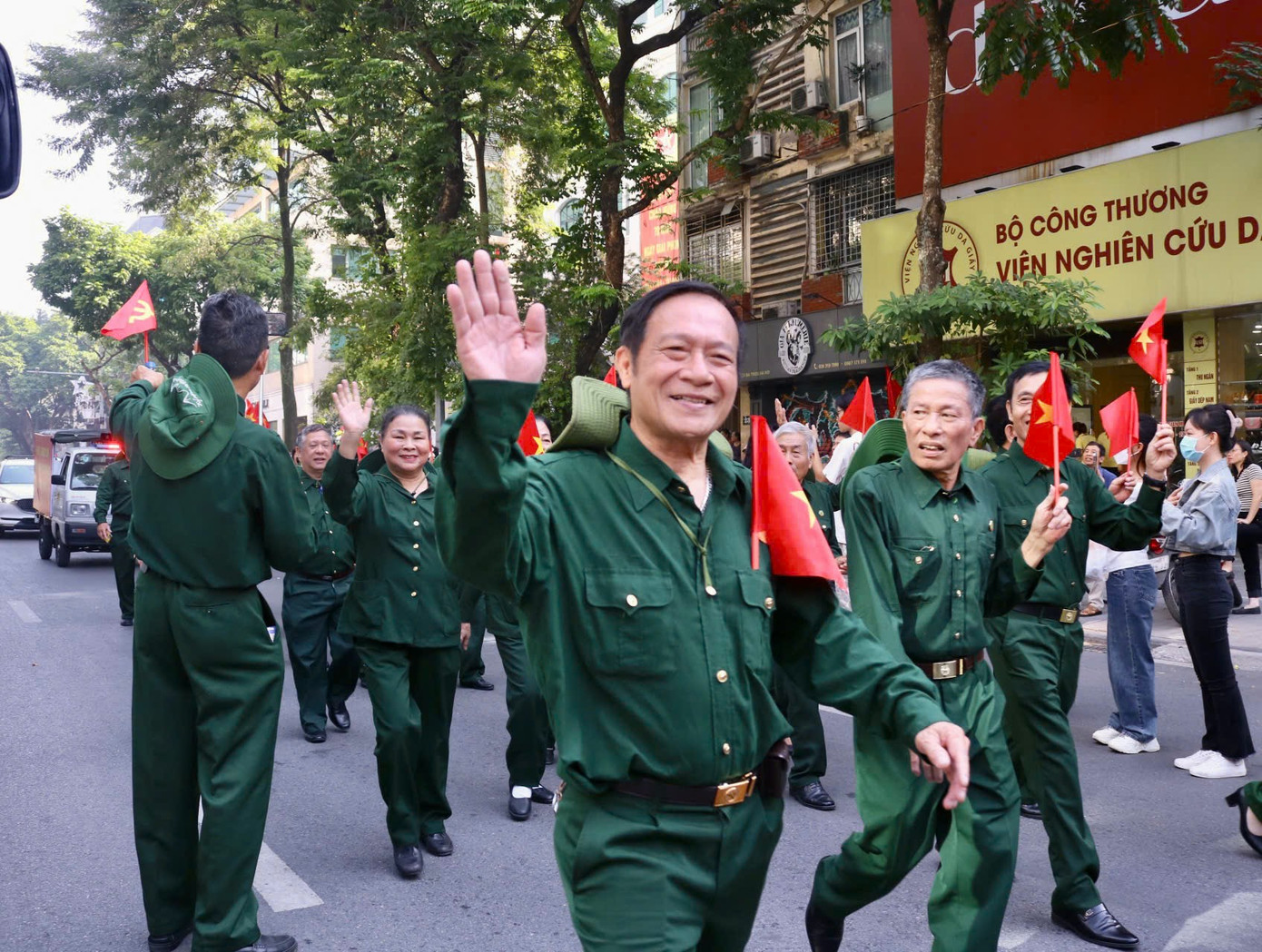 Nhiều người dân háo hức xuống đường để chờ đoàn diễu hành đi qua, trao cho nhau những cái nắm tay thân tình.