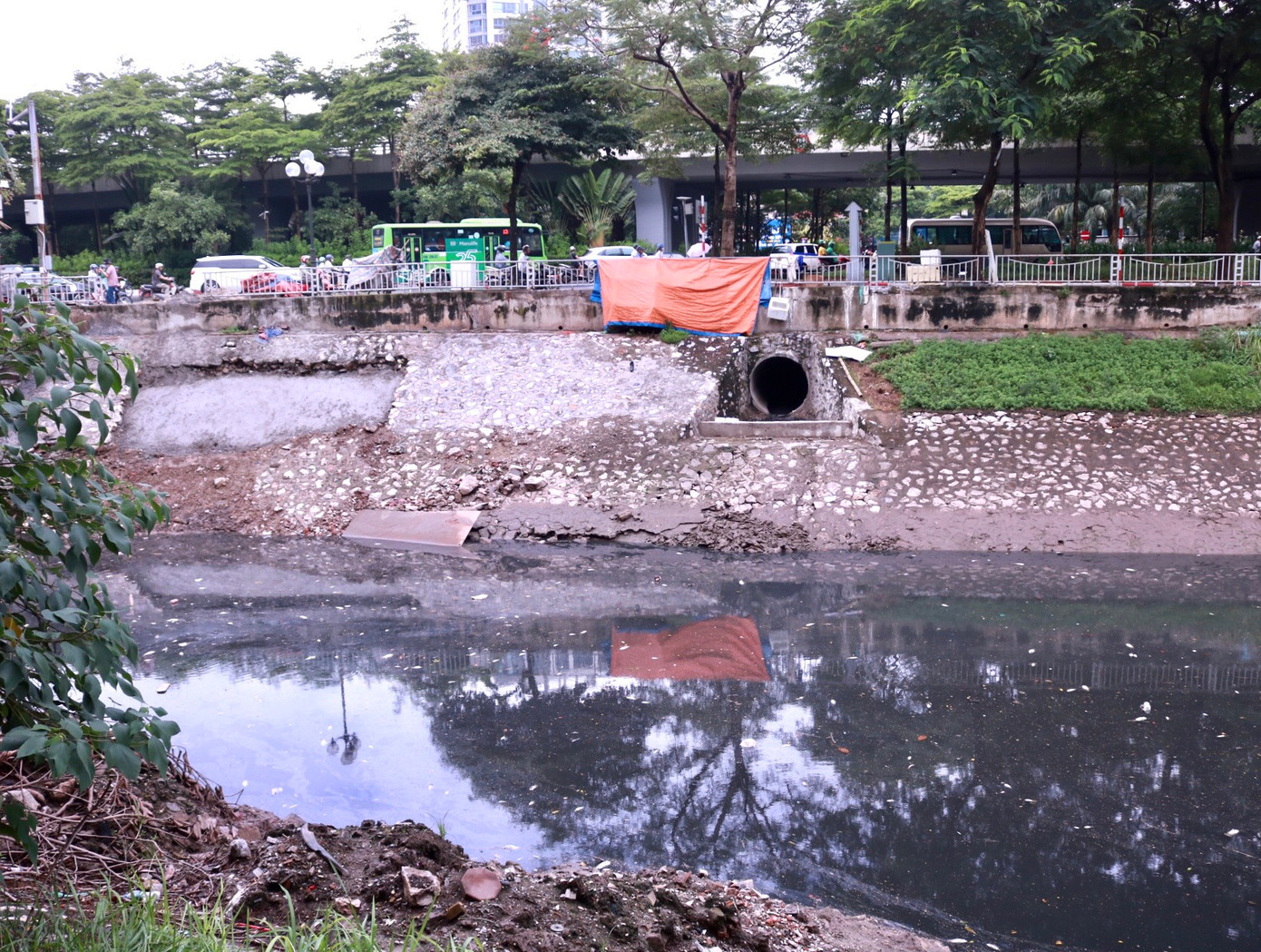 Ghi nhận tại khu vực cống xả ngay ngã tư Hoàng Quốc Việt - đường Bưởi, nước từ cống xả vẫn chảy nhưng với lưu lượng rất nhỏ, không thể tạo dòng chảy đẩy nước đọng đi.