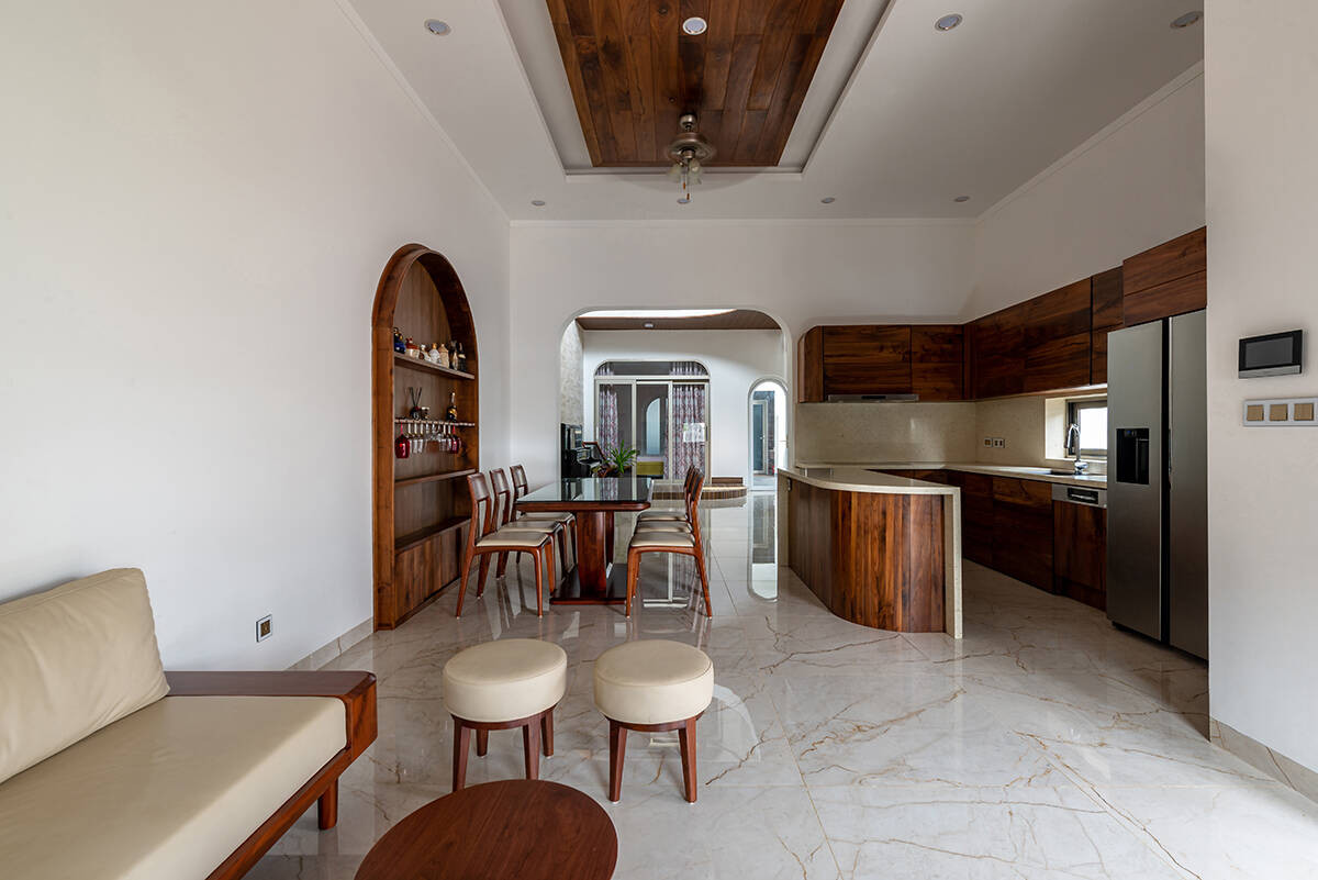 Ngôi nhà có phần phía trước là tổ hợp không gian mái hiên - phòng khách - bếp ăn liên thông với nhau. Thiết kế giúp tối đa hoá diện tích và phân chia rõ giữa không gian động và không gian tĩnh phía sau.