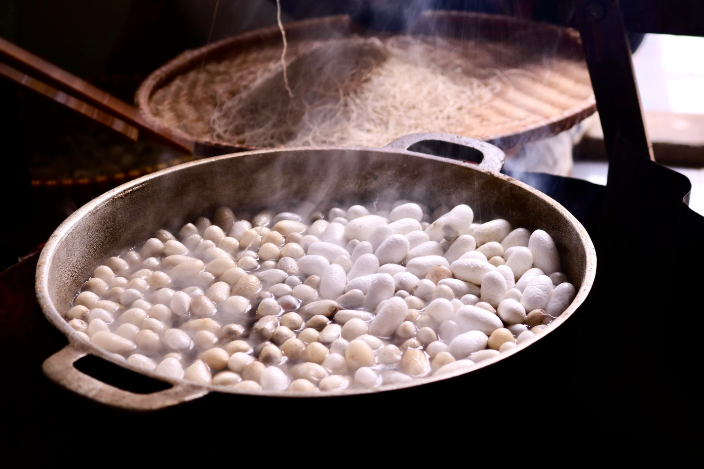 Bên cạnh nồi nước sôi sùng sục luôn có người túc trực để nấu kén, kéo sợi. Kén sẽ được vào một nồi nước sôi lớn, khuấy đều cho các kén nổi lên trên. Khi lớp áo đã bong ra, người trông bếp sẽ tìm mối gốc của tơ và rút ra rồi đưa lên guồng tơ nằm ngang trên nồi để quấn lại. Sợi tơ vừa mới rút ra được gọi là tơ thô, và sau đó chúng sẽ được se lại với nhau. Bên cạnh nồi nước sôi sùng sục luôn có người túc trực để nấu kén, kéo sợi. Kén sẽ được vào một nồi nước sôi lớn, khuấy đều cho các kén nổi lên trên. Khi lớp áo đã bong ra, người trông bếp sẽ tìm mối gốc của tơ và rút ra rồi đưa lên guồng tơ nằm ngang trên nồi để quấn lại. Sợi tơ vừa mới rút ra được gọi là tơ thô, và sau đó chúng sẽ được se lại với nhau.