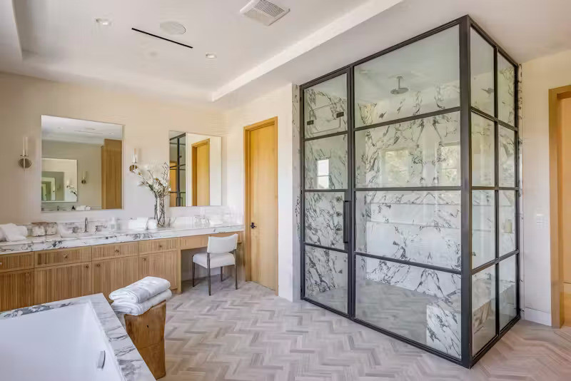 Phòng tắm rộng rãi với bồn tắm và một phần tường, bàn trang điểm được ốp đá.