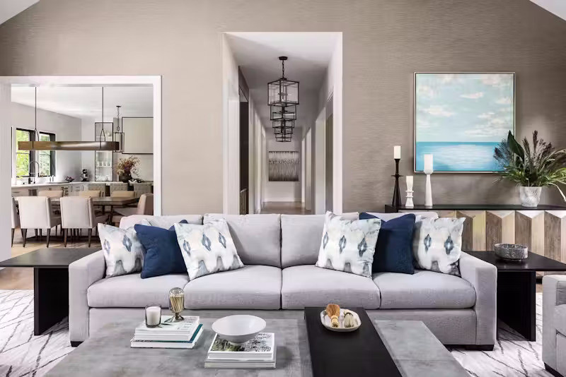 Điểm nhấn đáng chú ý trong không gian phòng khách là chiếc sofa dài, tạo sự thoải mái cho chủ nhà và khách khi vừa ngả lưng thư giãn vừa ngắm khung cảnh thiên nhiên. Không gian được bố trí cạnh khu vực bếp nướng ngoài trời, giúp việc kết nối bên trong và bên ngoài trở nên thuận tiện.