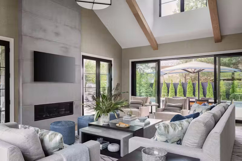 Điểm nhấn đáng chú ý trong không gian phòng khách là chiếc sofa dài, tạo sự thoải mái cho chủ nhà và khách khi vừa ngả lưng thư giãn vừa ngắm khung cảnh thiên nhiên. Không gian được bố trí cạnh khu vực bếp nướng ngoài trời, giúp việc kết nối bên trong và bên ngoài trở nên thuận tiện.