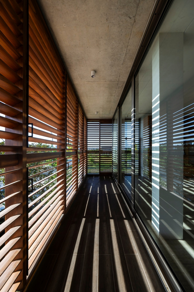Không gian phía Tây được thiết kế một lớp vách ngăn gỗ nhằm điều chỉnh nắng gắt chiếu trực tiếp vào nhà.