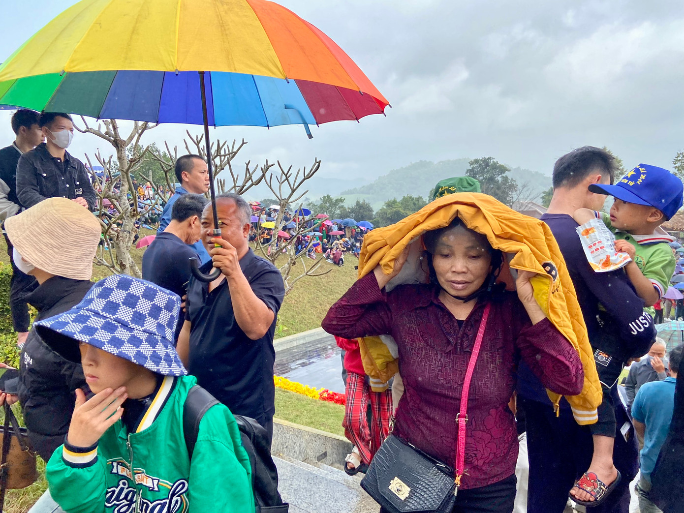 Người dân "đội mưa" dự khai hội.