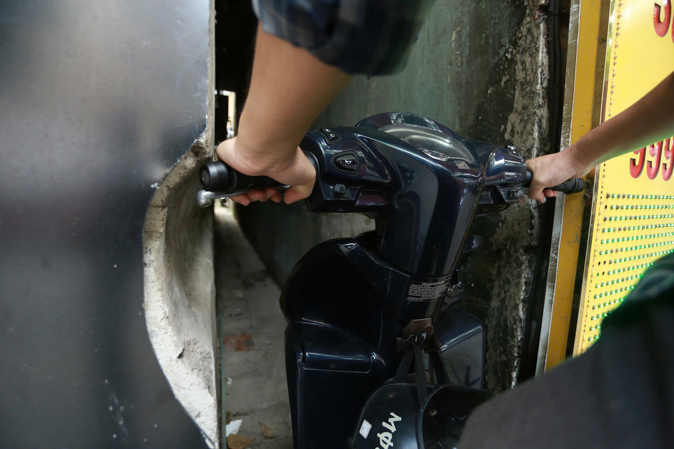 Không chỉ "chen chúc" khi di chuyển, người dân sống tại con ngõ 445 Bạch Mai còn phải đục một phần bức tường tại ngõ để xe máy có thể "len lỏi" vào nhà.