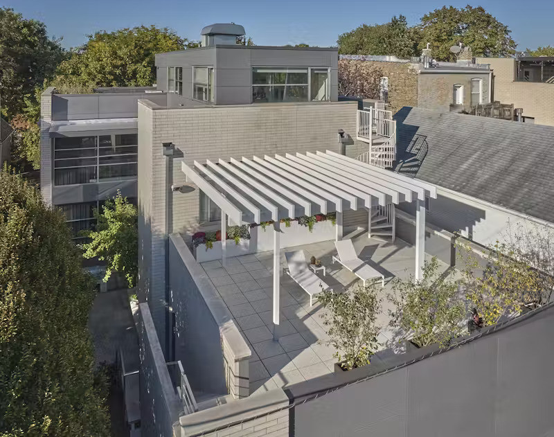 Trên sân thượng, gạch lát ceramic chịu lực được sử dụng để đảm bảo độ bền trong điều kiện thời tiết khắc nghiệt. Phía trên là hệ mái che bằng nhôm phủ sơn tĩnh điện, thiết kế riêng nhằm cung cấp bóng râm và điểm nhấn kiến trúc độc đáo cho tổng thể không gian.