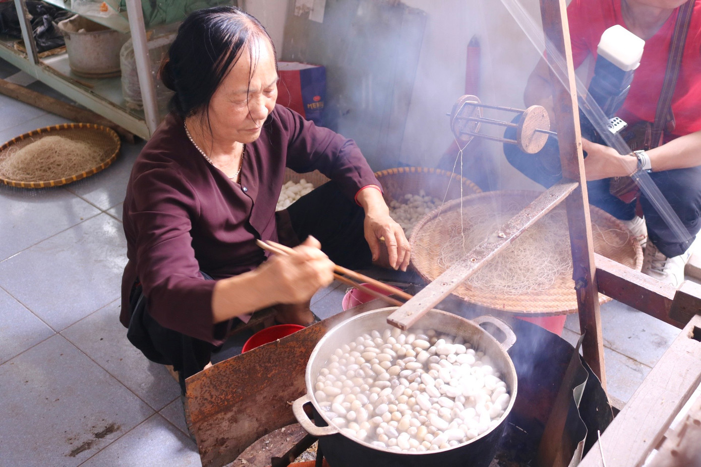Bên cạnh nồi nước sôi sùng sục luôn có người túc trực để nấu kén, kéo sợi. Kén sẽ được vào một nồi nước sôi lớn, khuấy đều cho các kén nổi lên trên. Khi lớp áo đã bong ra, người trông bếp sẽ tìm mối gốc của tơ và rút ra rồi đưa lên guồng tơ nằm ngang trên nồi để quấn lại. Sợi tơ vừa mới rút ra được gọi là tơ thô, và sau đó chúng sẽ được se lại với nhau. Bên cạnh nồi nước sôi sùng sục luôn có người túc trực để nấu kén, kéo sợi. Kén sẽ được vào một nồi nước sôi lớn, khuấy đều cho các kén nổi lên trên. Khi lớp áo đã bong ra, người trông bếp sẽ tìm mối gốc của tơ và rút ra rồi đưa lên guồng tơ nằm ngang trên nồi để quấn lại. Sợi tơ vừa mới rút ra được gọi là tơ thô, và sau đó chúng sẽ được se lại với nhau.