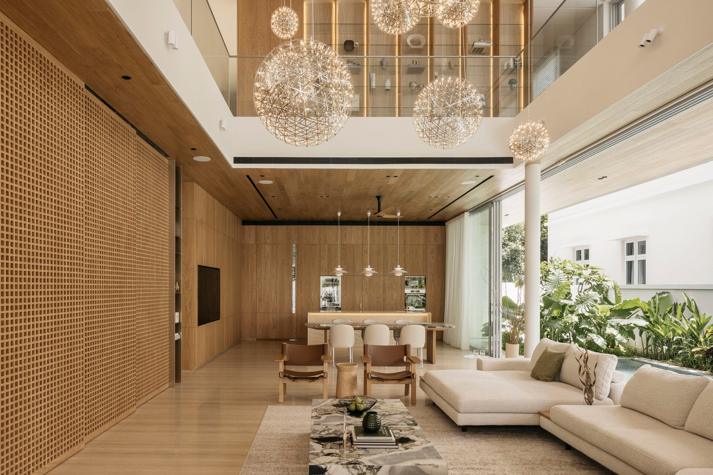 Ngay khi bước vào độ cao ấn tượng của không gian phòng khách được nhấn mạnh bởi những cụm đèn thả nghệ thuật ở chiều cao khác nhau.