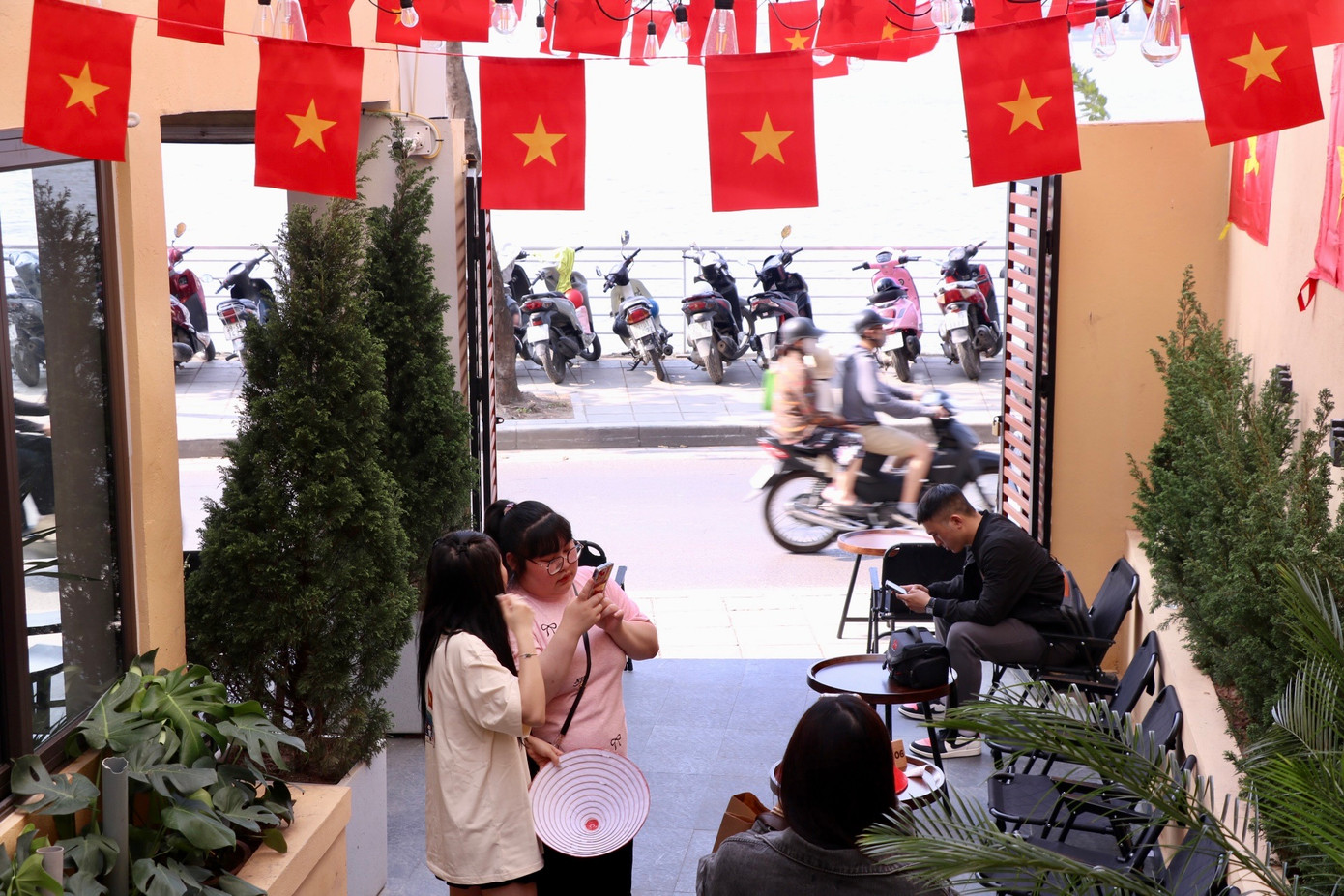 Không gian rực rỡ sắc đỏ và vàng, cờ Tổ quốc được treo trang trọng trong không gian quán cà phê đã thu hút không ít các bạn trẻ đến check-in, lưu lại khoảnh khắc đáng nhớ. Điều tưởng chừng bình thường giản dị ấy đang trở thành một trào lưu đầy cảm hứng trên mạng xã hội những ngày cận lễ 30/4 - 1/5.