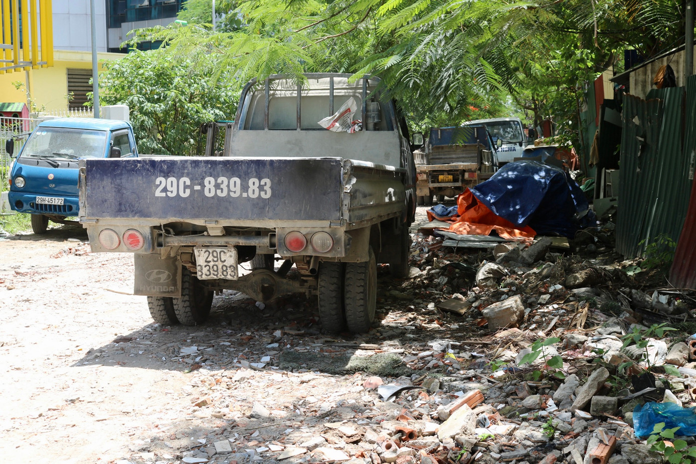 Rìa đường rác thải, gạch vỡ tràn lan. Thêm vào đó, hàng loạt ôtô còn đậu đỗ dày đặc bên đường, gây mất mỹ quan đô thị.