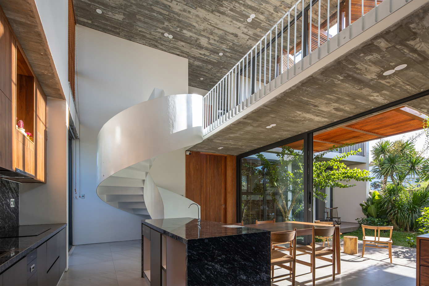 Bếp được thiết kế tối giản với khu vực nấu, một quầy bar nhỏ. Không gian bếp được kết nối trực tiếp với khoảng xanh bên ngoài qua cửa kính trượt tấm lớn tạo cảm giác thoáng, rộng hơn cho khu bếp.