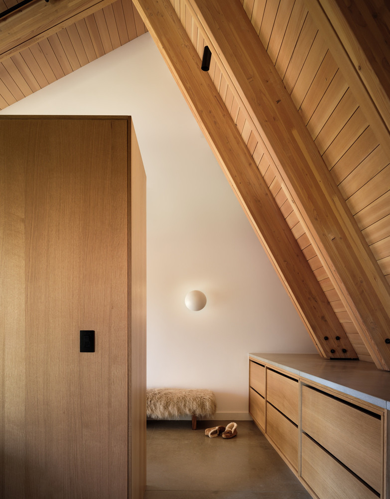 Trần gỗ thông đỏ tạo nên sự ấm áp bên trong cho ngôi nhà. Các dầm gỗ được căn chỉnh hài hoà với hệ tủ phía dưới, mang đến cảm giác nhịp nhàng và yên bình.