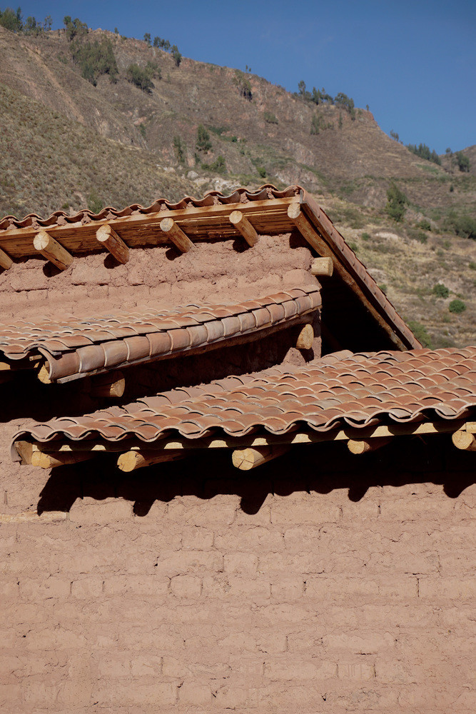 Lấy cảm hứng từ mái nhà Andes truyền thống, hệ mái kép được bố trí phủ lên hai khối nhà chính. Các xà nhà được đặt song song với tuyến đường dẫn ra sông Vilcanota, nằm trên một bức tường đất dày 80cm vừa phân chia không gian, vừa là trụ đỡ cho hai trong ba xà chính.