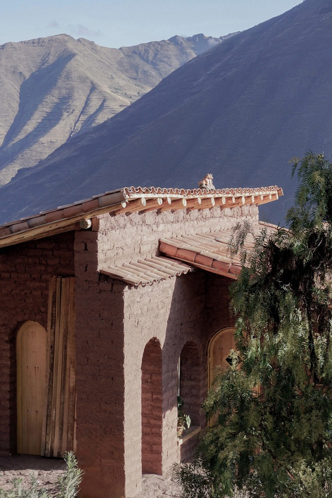 Tại tầng chính, bức tường đất phía Tây được mở rộng để hấp thụ tối đa năng lượng mặt trời. Thiết kế cửa cao và cửa sổ lớn mang lại nguồn ánh sáng tự nhiên dồi dào, đồng thời phá vỡ sự khép kín thường thấy ở tường đất, tạo nên kết nối thị giác liên tục từ đầu này sang đầu kia căn nhà.