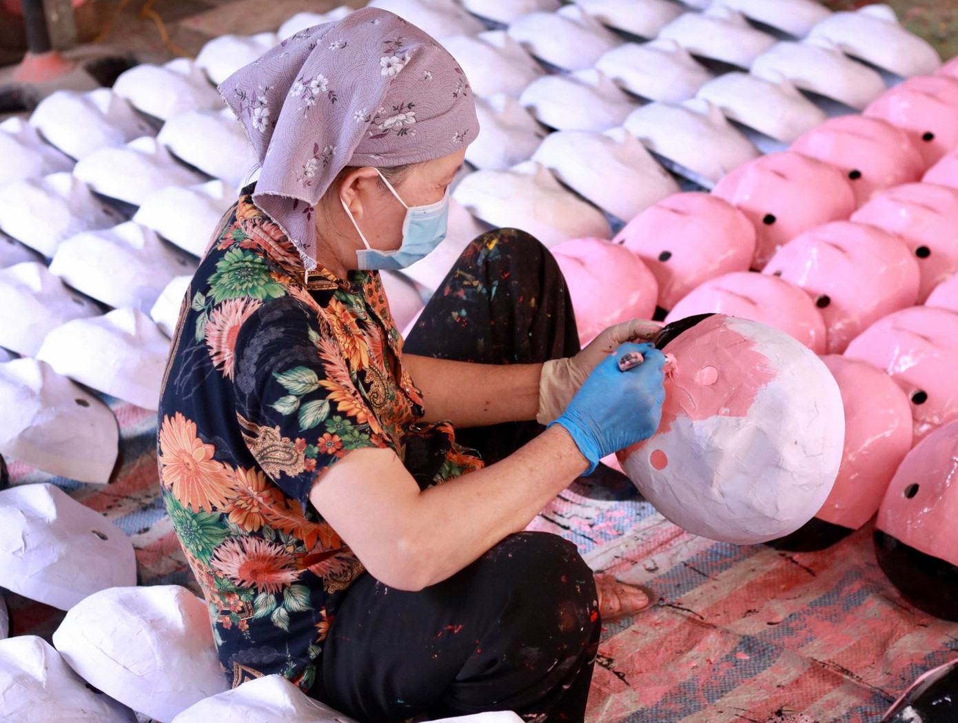 Ông Đông cho biết, trước kia, gia đình ông tự thực hiện các công đoạn từ bồi giấy đến vẽ nhưng hiện tại có nhiều đơn đặt hàng nên gia đình ông thuê thêm nhân công bồi giấy và sơn để đảm bảo tiến độ, vợ chồng ông chủ yếu hoàn thiện việc vẽ tạo thành phẩm. "Mẫu mã mặt nạ ngày xưa cũng không đa dạng như bây giờ mà chỉ có hình ông Tễu. Dần dần chúng tôi đã tìm cách cải tạo để có thêm nhiều mẫu mã mới, đáp ứng nhu cầu của người tiêu dùng".