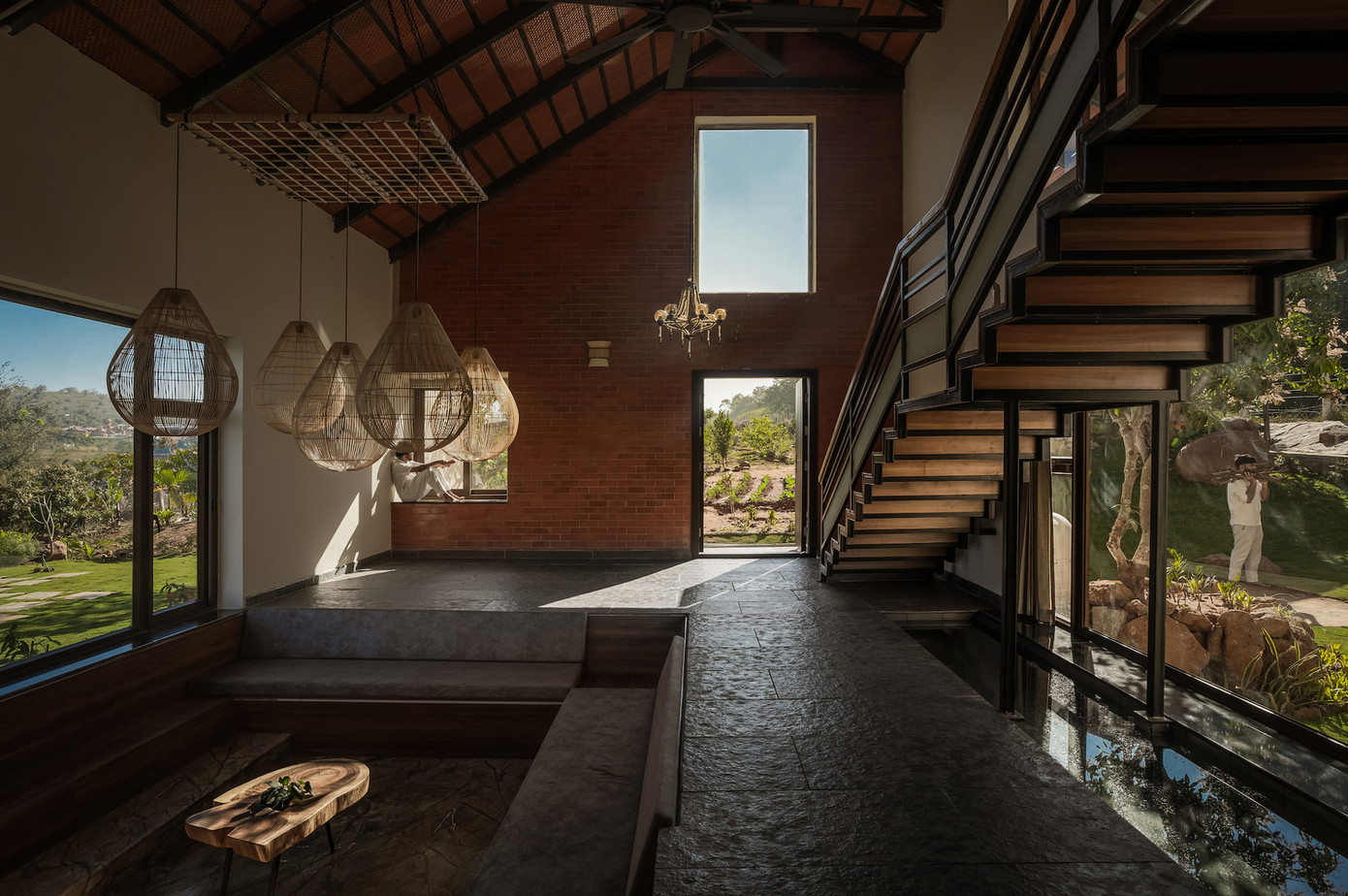 Phòng khách được bố trí thấp hơn nhẹ so với mặt bằng chính, nằm giữa hồ bơi bên ngoài và hồ cá koi tĩnh lặng bên trong - một dụng ý thiết kế khéo léo nhằm tăng cường cảm nhận về không gian. Một cầu thang đơn nhịp kéo dài dọc theo không gian sinh hoạt tạo điểm nhấn về chiều cao và chiều sâu, đồng thời làm nổi bật thể tích trần cao gấp đôi. Phòng khách được bố trí thấp hơn nhẹ so với mặt bằng chính, nằm giữa hồ bơi bên ngoài và hồ cá koi tĩnh lặng bên trong - một dụng ý thiết kế khéo léo nhằm tăng cường cảm nhận về không gian. Một cầu thang đơn nhịp kéo dài dọc theo không gian sinh hoạt tạo điểm nhấn về chiều cao và chiều sâu, đồng thời làm nổi bật thể tích trần cao gấp đôi.