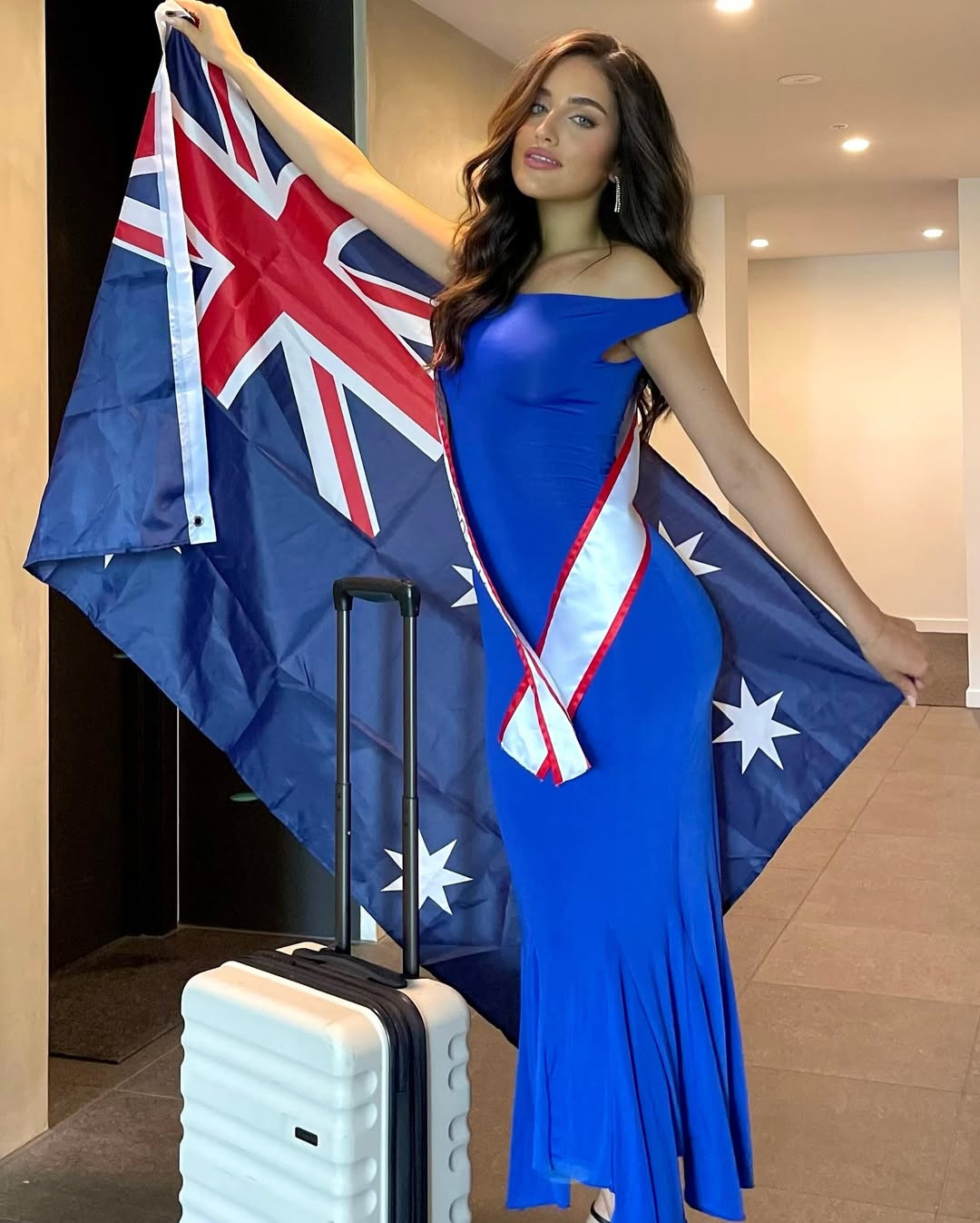 Đại diện Australia - Alana Deutsher-Moore - diện váy xanh bó sát ở sân bay.