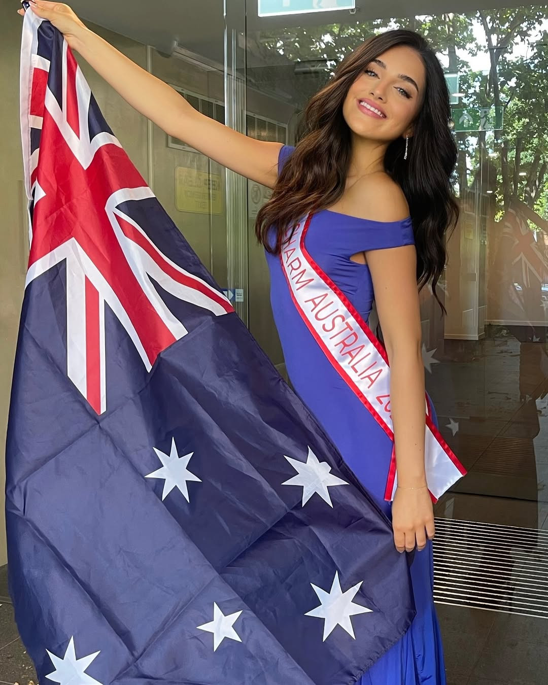 Đại diện Australia - Alana Deutsher-Moore - diện váy xanh bó sát ở sân bay.