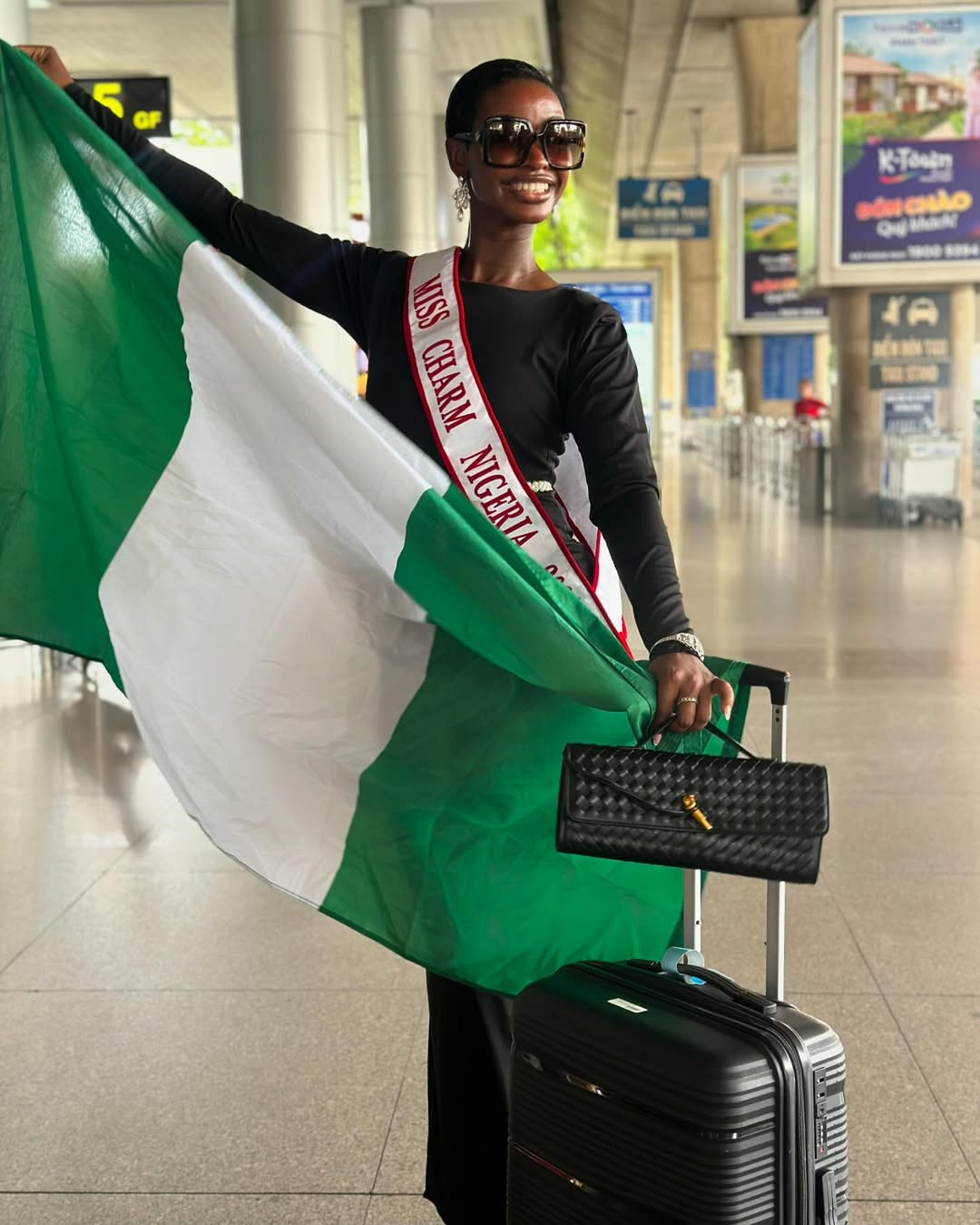 Miss Charm Nigeria - Hannah Onosetale Iribhogbe - mang theo cờ Tổ quốc.