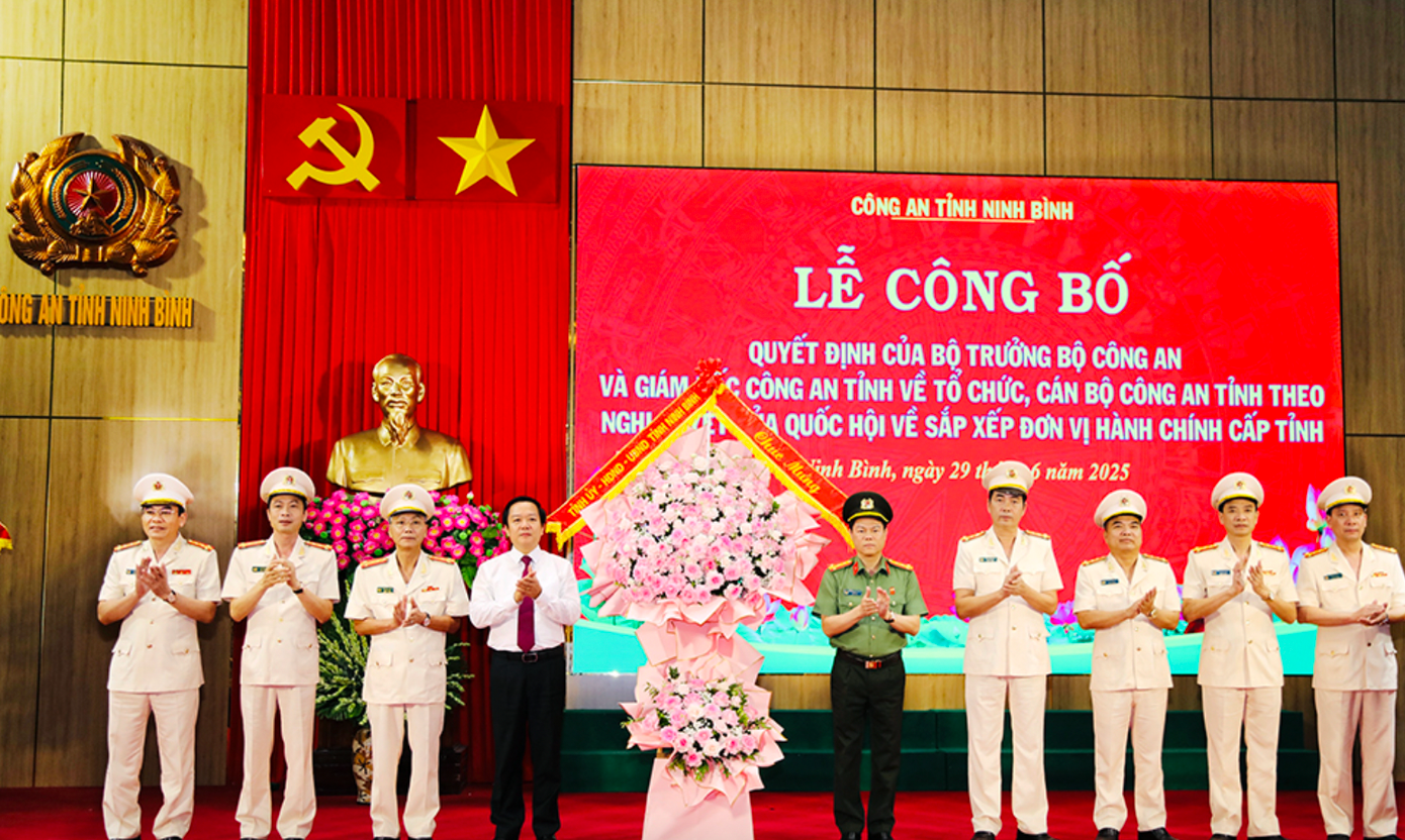 Đồng chí Chủ tịch UBND tỉnh Phạm Quang Ngọc tặng hoa chúc mừng Ban Giám đốc Công an tỉnh. Ảnh: Đức Lam.