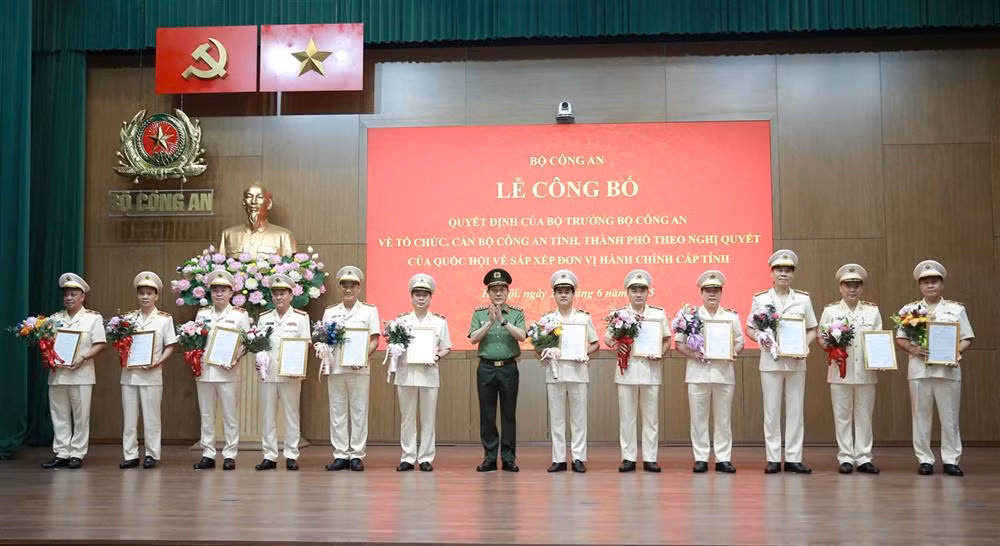 Bộ trưởng Lương Tam Quang trao quyết định và tặng hoa chúc mừng 23 đồng chí Giám đốc Công an địa phương sau sáp nhập.