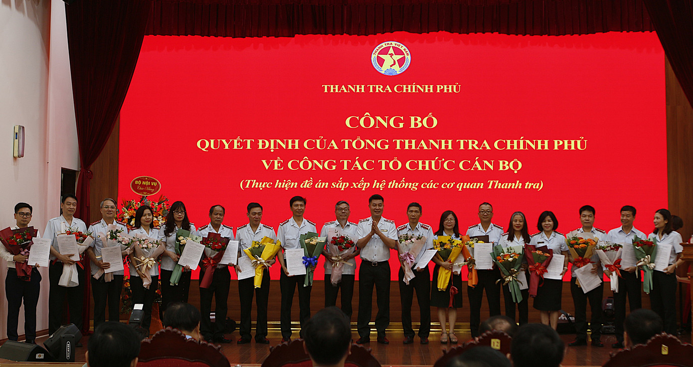 Phó Tổng Thanh tra Chính phủ Dương Quốc Huy trao quyết định và tặng hoa chúc mừng các đồng chí được tiếp nhận, điều động và bổ nhiệm. Ảnh: Mạnh Đạt.