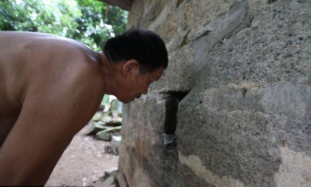 Ông bố theo dõi cuộc sống của con trai qua khe hở. Ông bà cho biết, bản thân ông bà nay cũng không thể làm được gì để kiếm sống bởi tuổi già 