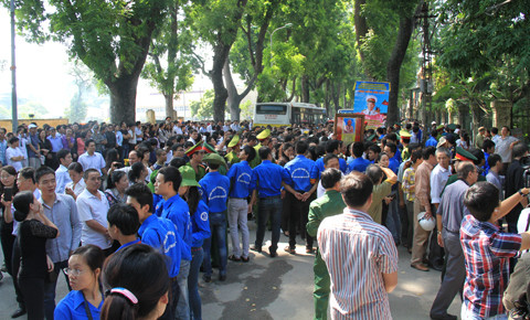 Lực lượng sinh viên tình nguyện làm hàng rào xanh trước cổng nhà Đại tướng để tránh gây ùn tắc, chen lấn, xô đẩy