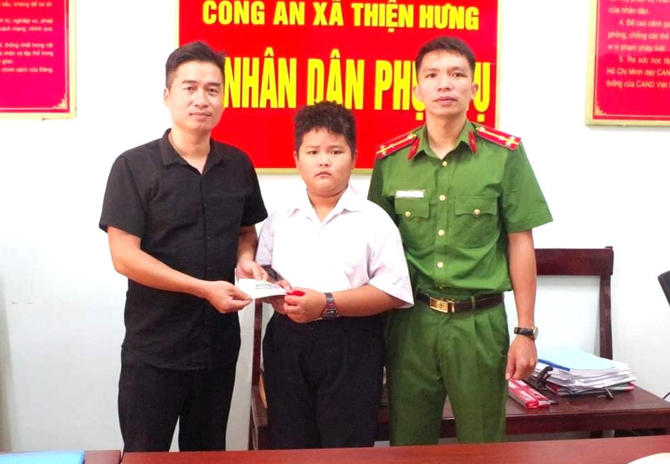 Em Hoàng Gia Bảo (giữa) trao trả lại tiền cho người đánh rơi