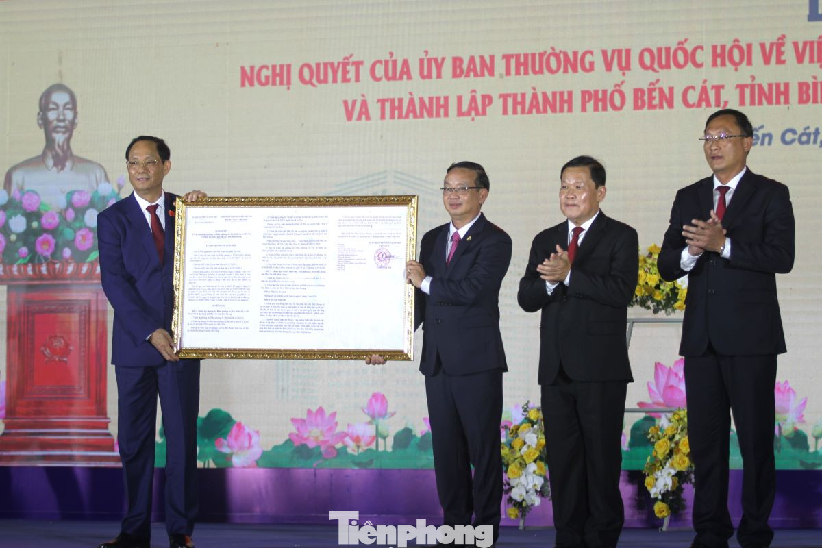 Phó Chủ tịch Quốc hội Trần Quang Phương (bìa trái) trao Nghị quyết về việc thành lập thành phố Bến Cát