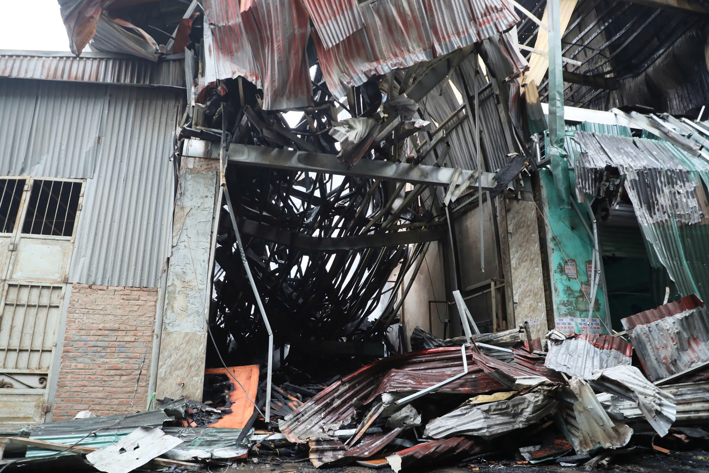 Dưới sức nóng của ngọn lửa, mái tôn bị biến dạng, đổ sập. Dưới sức nóng của ngọn lửa, mái tôn bị biến dạng, đổ sập.